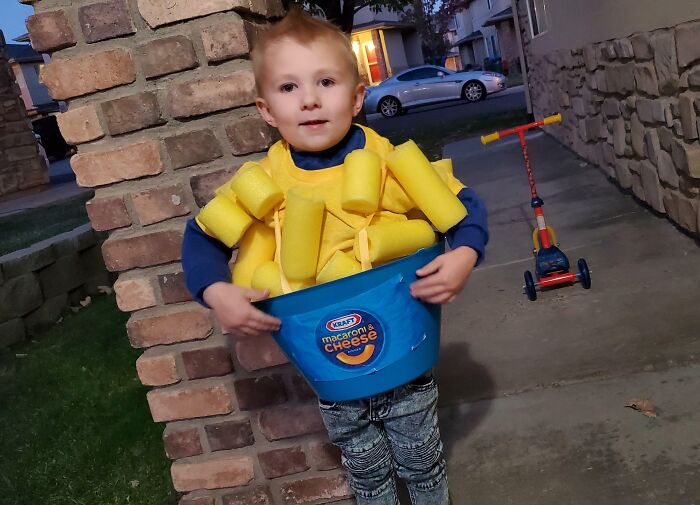 Child in creative macaroni and cheese Halloween costume outside, showcasing amazing kids' Halloween costume ideas.