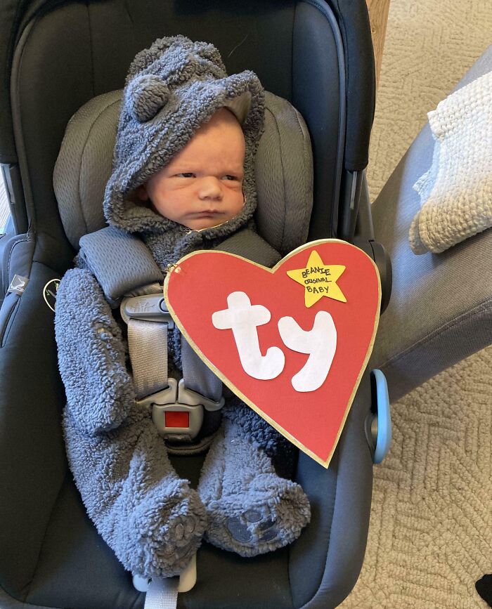 Baby dressed in an adorable fuzzy bear costume with a red Beanie Baby heart for kids Halloween costume ideas.