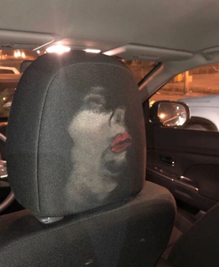 Car headrest with a hilarious face impression that accidentally became an instant meme in a dimly lit parking area.