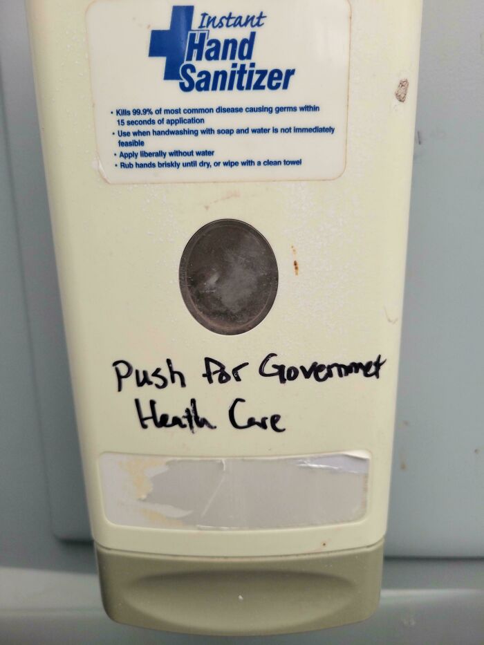 Hand sanitizer dispenser with handwritten text pushing for government healthcare, highlighting American healthcare realities.