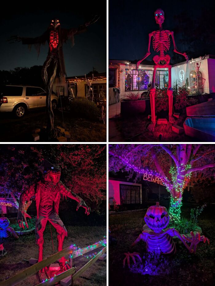Outdoor Halloween decorations featuring large illuminated skeletons and spooky figures with colorful lighting at night.
