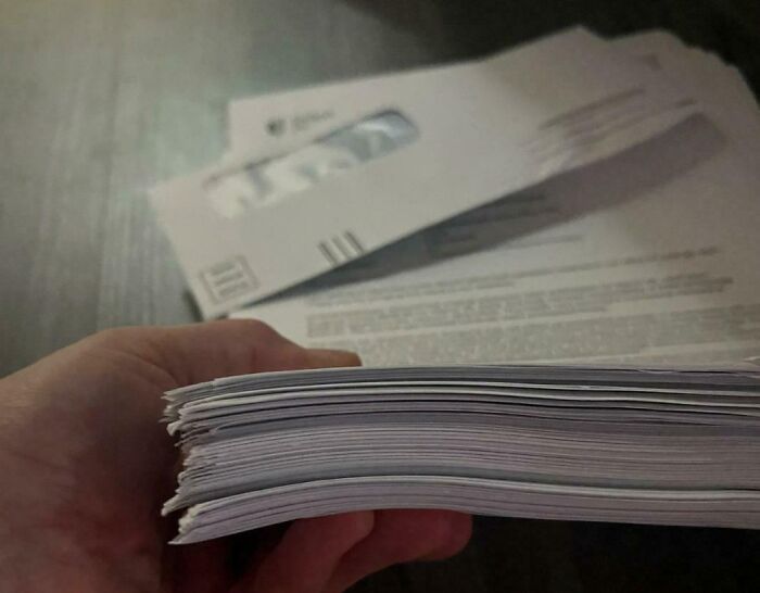 Thick stack of medical bills held in hand, illustrating the harsh realities of American healthcare expenses.
