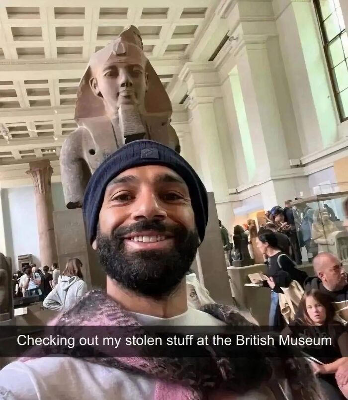 Man smiling in front of an ancient statue inside a museum, a funny meme about stolen artifacts and memes humor.