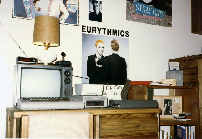 1980s vintage computer with CRT TV, retro music posters, and wooden furniture capturing wild and wonderful decade vibes.