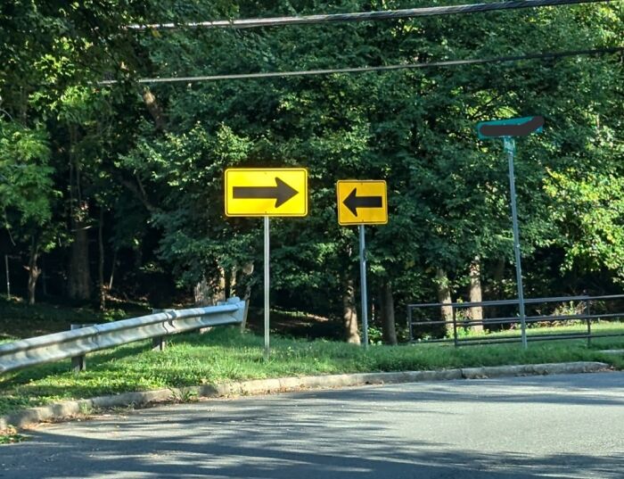 Two confusing road signs with arrows pointing left and right at a street corner, illustrating confusing road signs.