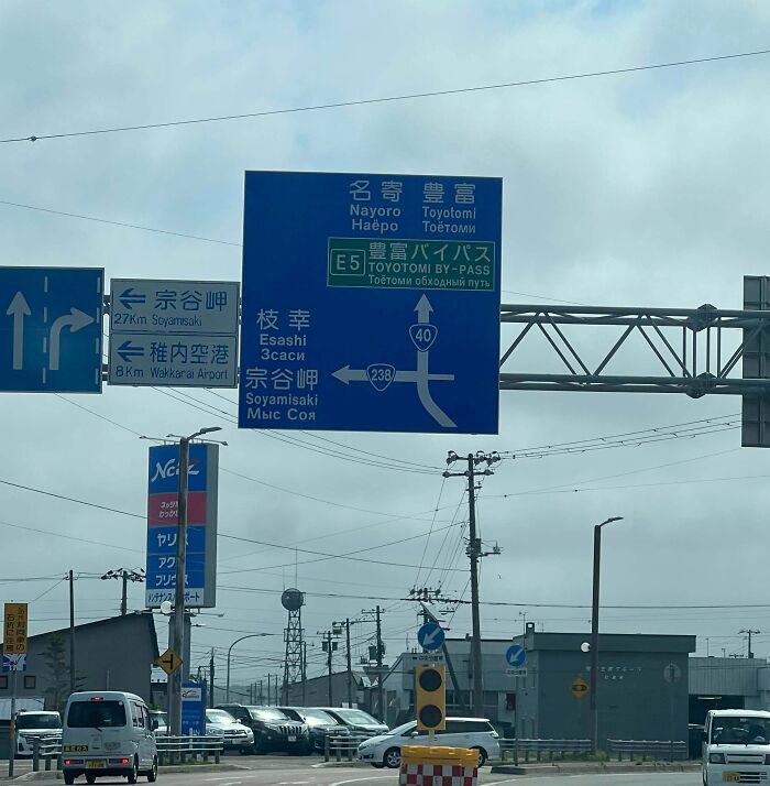 Confusing road signs in Japan with multiple directions and languages, causing drivers to ignore GPS navigation.