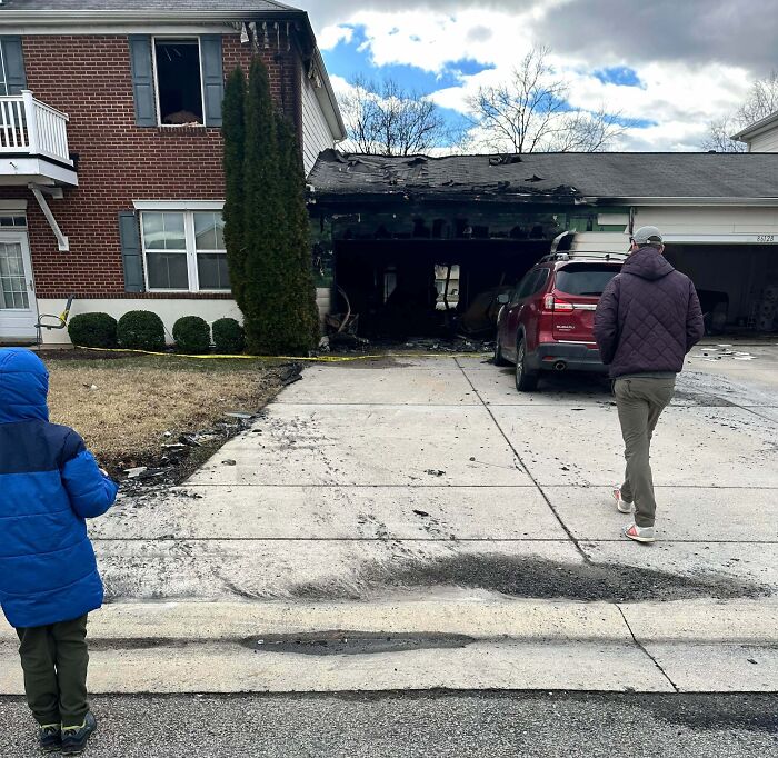 Burned garage and driveway with two people nearby, illustrating mildly infuriating things that tested patience.