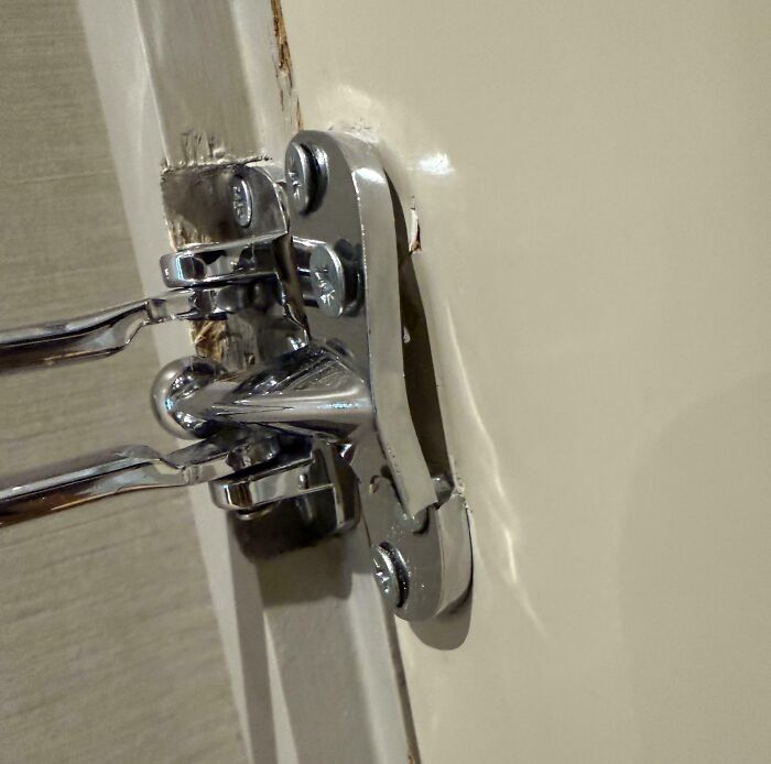 Close-up of a door latch installed incorrectly with visible gaps, one of the mildly infuriating things testing patience.