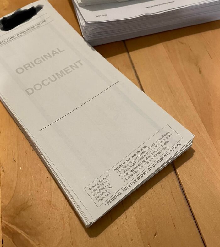 Stack of medical bills on a wooden table highlighting the harsh realities of American healthcare costs and paperwork.