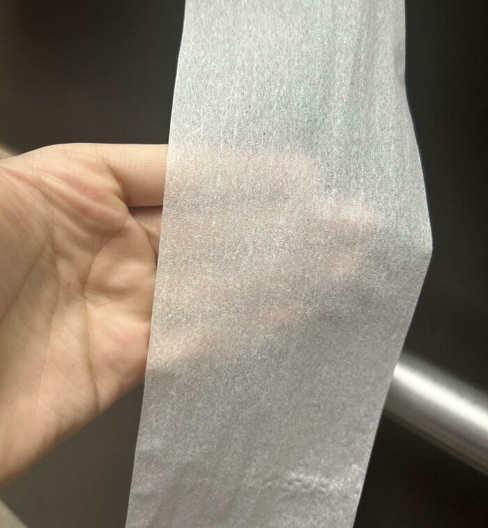 Hand holding a thin, almost transparent tissue paper, illustrating mildly infuriating things testing patience.