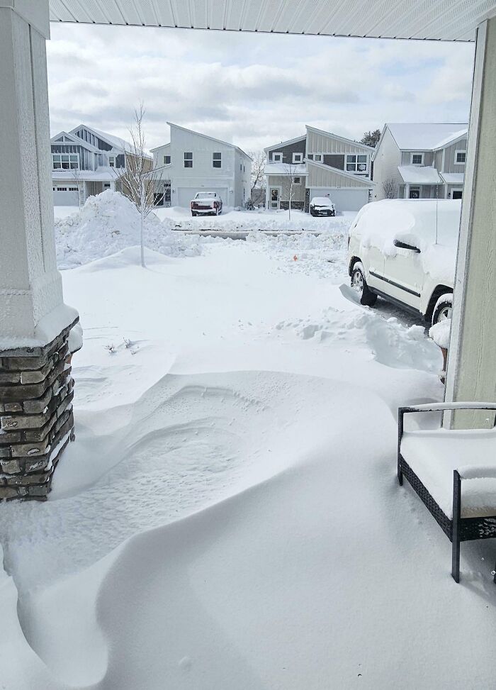 Snow-covered driveway and cars in a neighborhood, illustrating mildly infuriating things that test patience in winter.