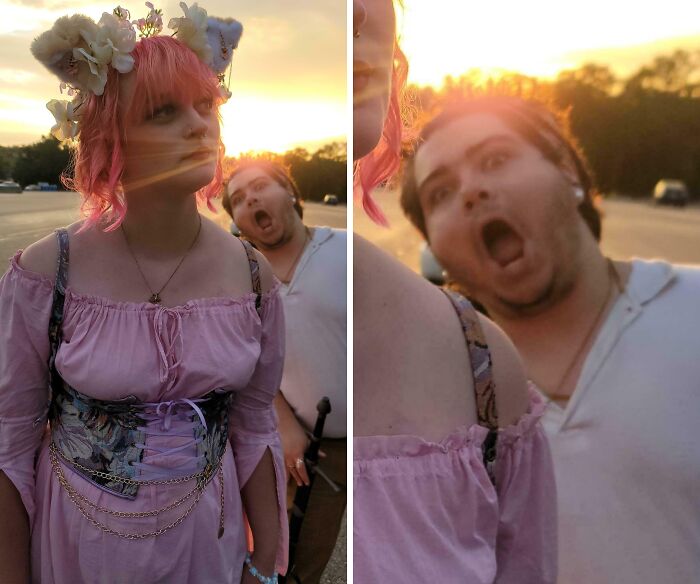 A man photobombing a woman in a pink dress and floral headpiece during a sunset, capturing a perfect photobomb moment.