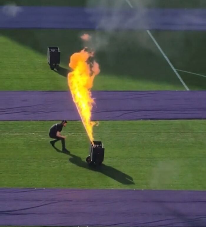 Technician managing large flame effects on field, illustrating a job that should pay more from unsettling worker photos.