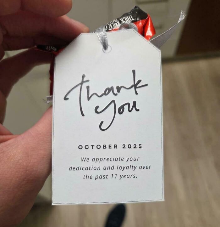 Hand holding a torn candy wrapper with a thank you tag, a mildly infuriating thing that tests people’s patience.