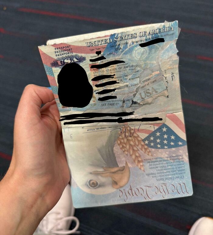 Worn and partially torn US passport held open, showing damage that tests people’s patience in travel documents.