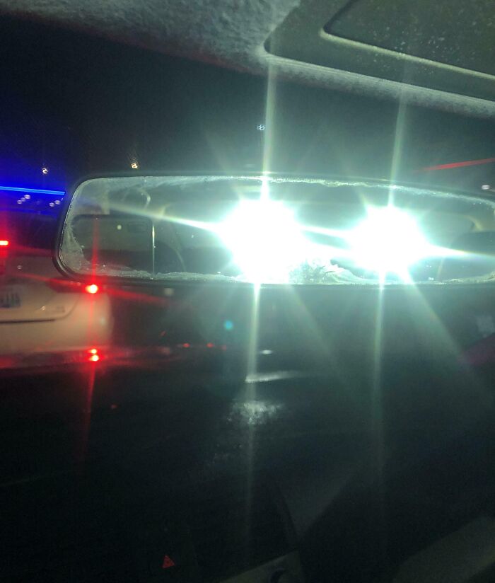 Bright headlights shining directly into a rearview mirror, a mildly infuriating thing testing drivers’ patience at night.