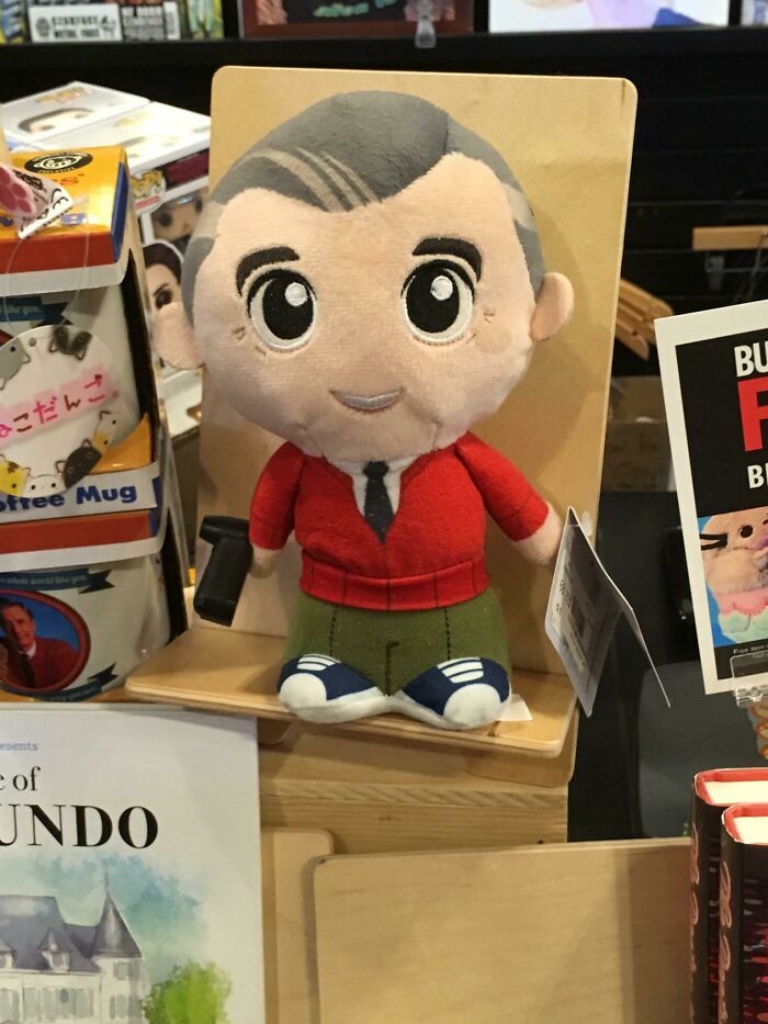 Plush toy in red sweater with large eyes and funny expression, showcasing accidental comedy in a store display.