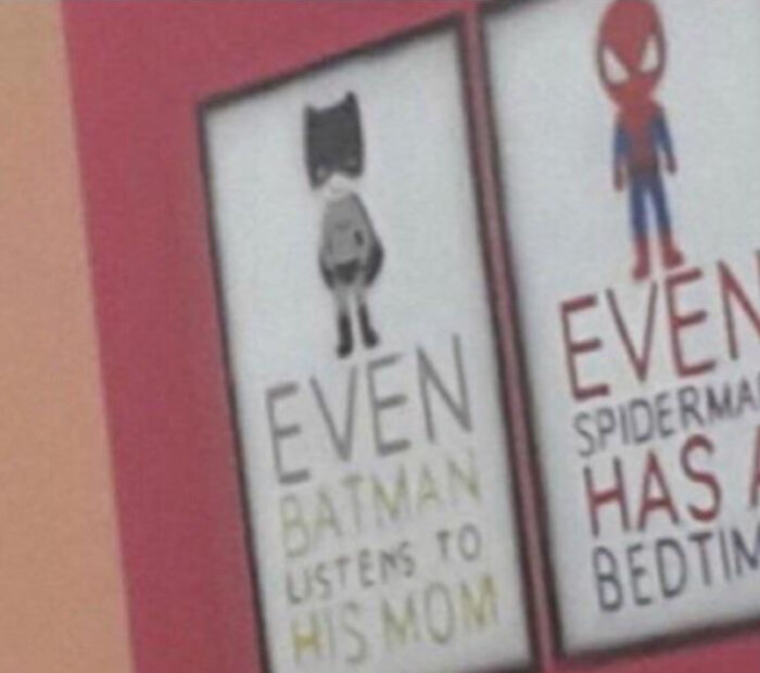 Funny accidental comedy image showing humorous superhero signs with Batman and Spiderman sayings on a wall.