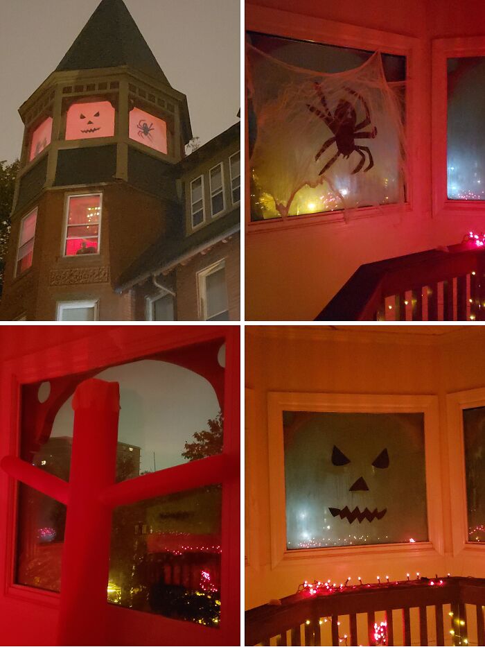 Outdoor Halloween decorations featuring spooky window designs with jack-o'-lantern faces, spiders, and red lighting at night