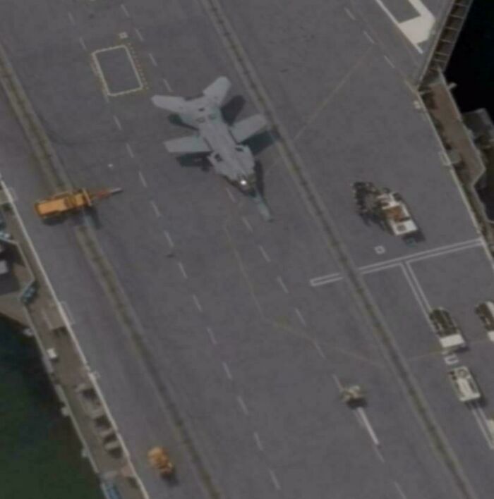 Aerial view from Google Earth showing a military jet on a ship deck, capturing something totally unexpected.