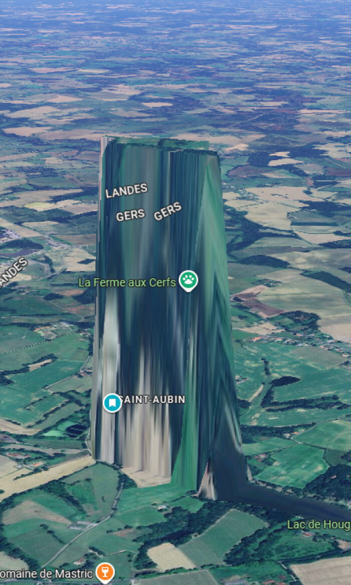 Glitched terrain on Google Earth map showing distorted vertical elevation over rural landscape in Gers region.