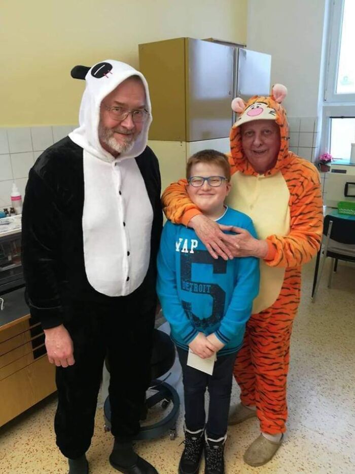 Two doctors in panda and tiger costumes with a smiling boy in a blue sweater, showing wholesome things doctors did to ease patients.