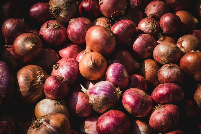 Close-up of red and brown onions piled together, illustrating interesting and little-known facts about Vikings.