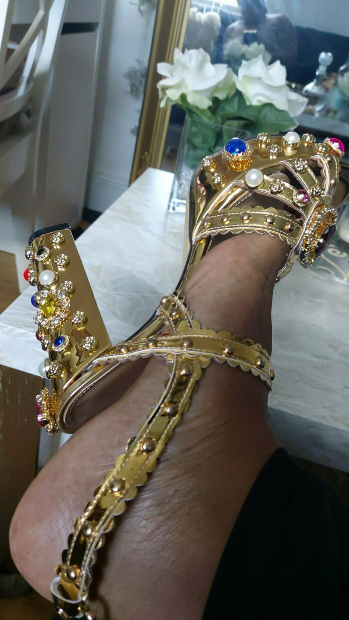 Gold high heel sandal with colorful jewels on foot, showcasing a careless online shopping fail in footwear design.