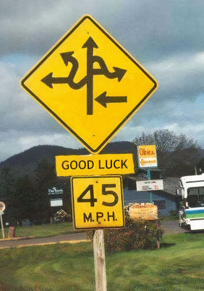 Confusing road sign with multiple directions and a good luck message, illustrating confusing road signs and ignoring GPS.