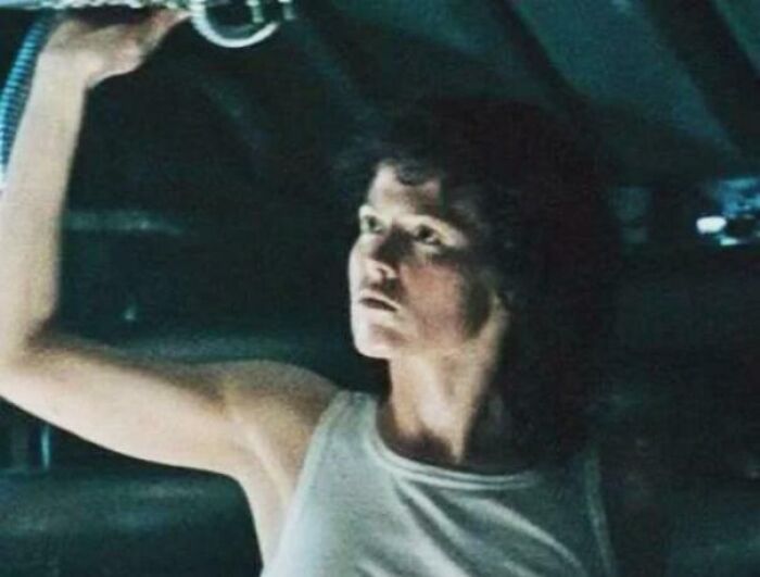 Woman holding a flashlight in a dark scene, illustrating confusing bad movie details from an online group discussion.