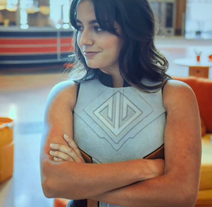 Woman in futuristic outfit with folded arms, representing bad movie details and confusing scenes in an online group.