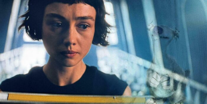 Young woman with short dark hair looking confused in a dimly lit scene, highlighting bad movie details and confusing moments.