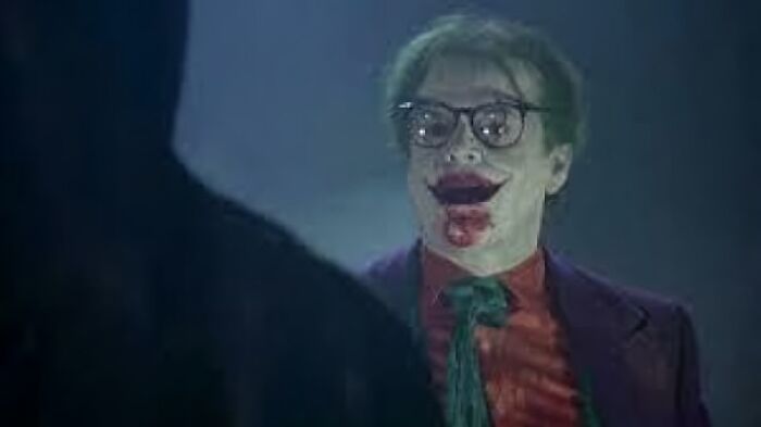 Character dressed as the Joker with smeared makeup, representing bad movie details in a confusing scene.