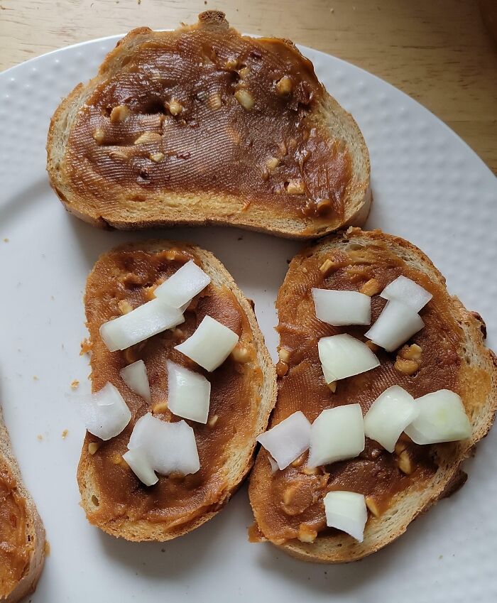 Slices of bread with peanut butter and raw chopped onions, a cursed and disgusting food combination.