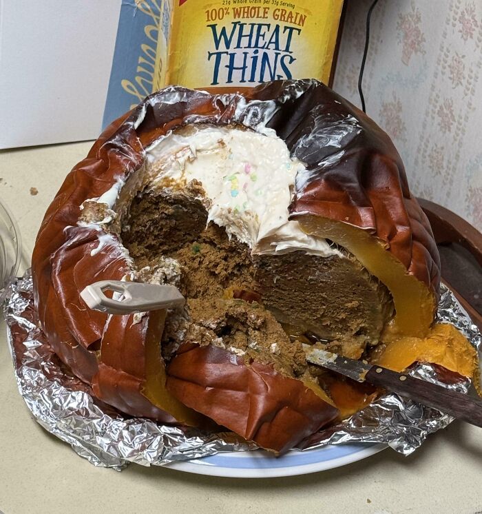 Rotten pumpkin filled with spoiled cake and frosting on a plate, showing cursed and disgusting food decay.