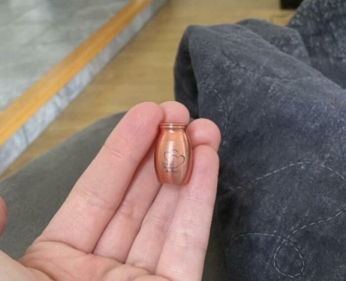Hand holding a miniature urn, an example of careless online shopping backfiring in a humorous way.