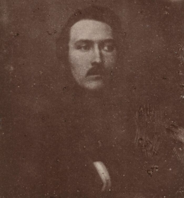 Old sepia toned photo of a man with a mustache, one of the rare surviving images from early photography times.