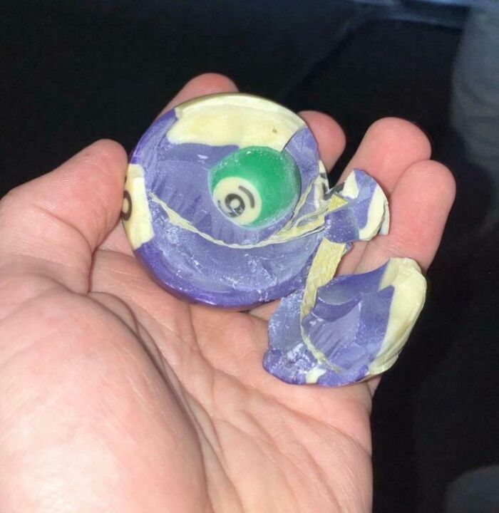 Hand holding a broken candy shaped like a colorful fish, moderately interesting object shared online.