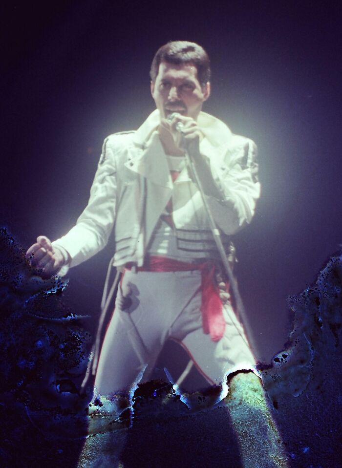 Freddie Mercury performing live in iconic 1980s outfit, captured in a wild and wonderful moment from the era.