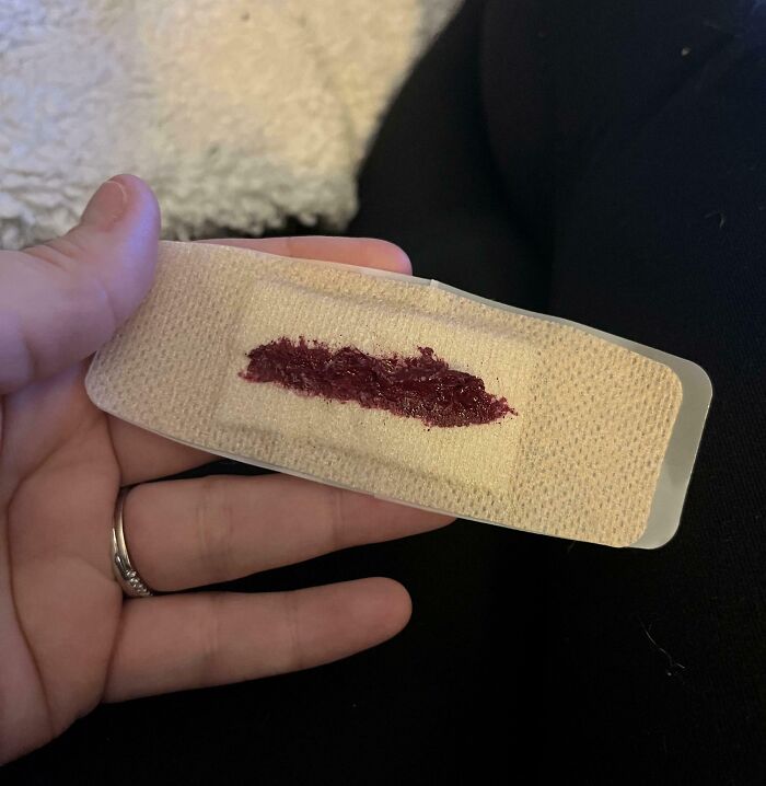 Hand holding a bandage with fake blood, showing one of the Halloween fails that put a damper on the spooky day.