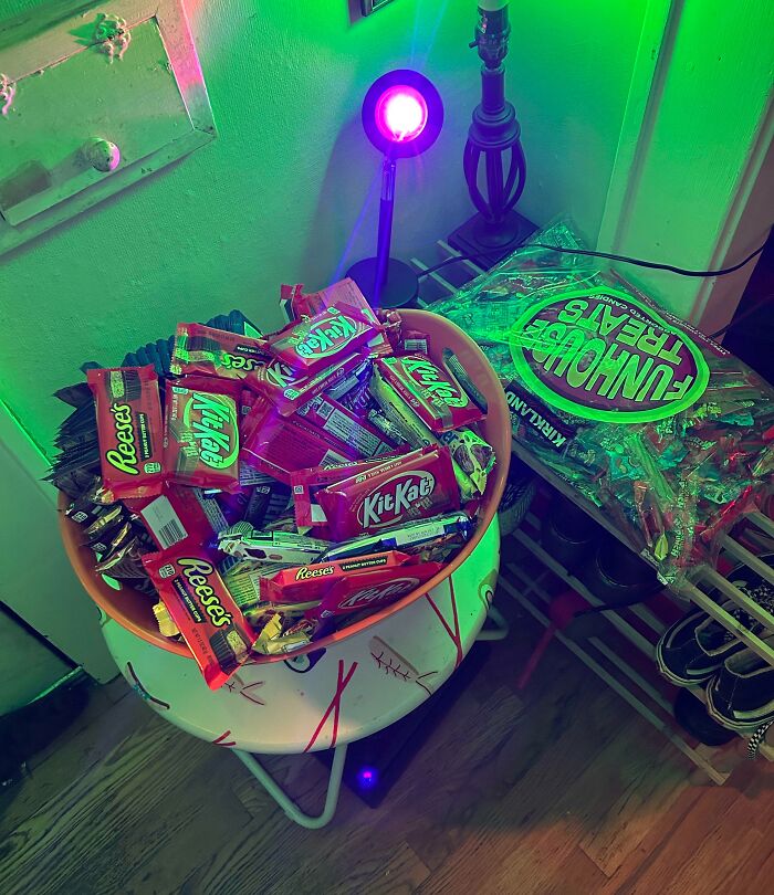 Basket full of Halloween candy including KitKat and Reese's under green lighting, illustrating Halloween fails with treats.
