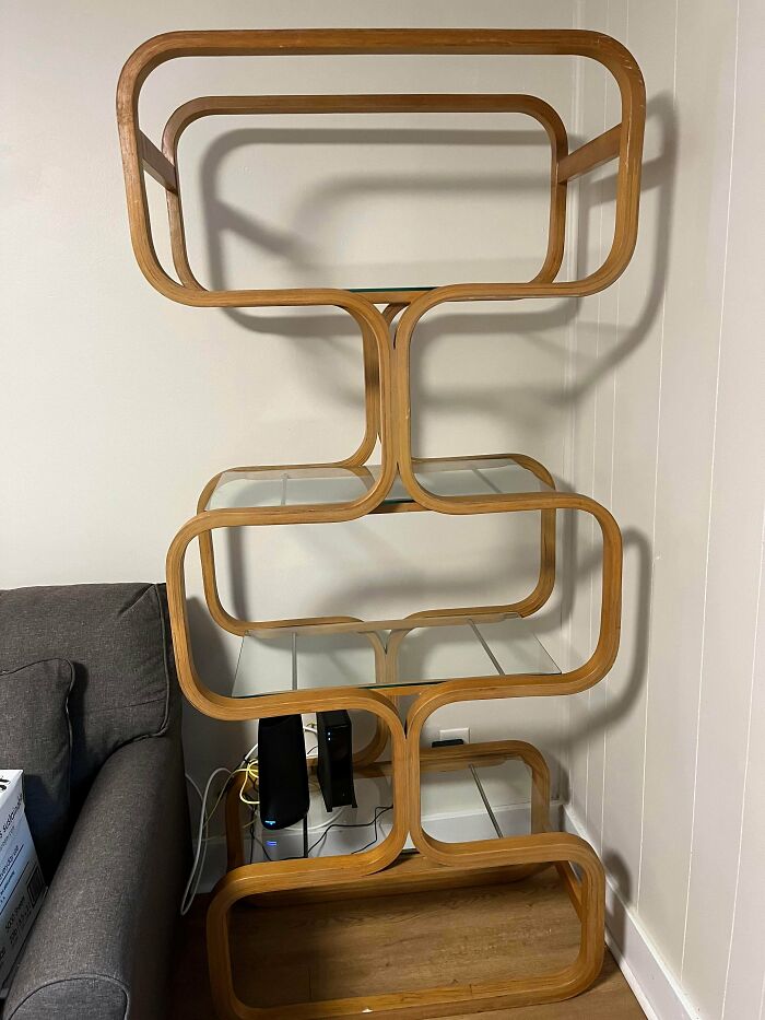 Mid-century modern curved wood and glass shelf unit found by lucky thrift store shoppers at a jackpot sale.