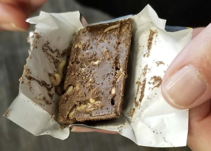 Close-up of a Halloween fail showing a partially unwrapped melted chocolate bar with ants crawling on it.