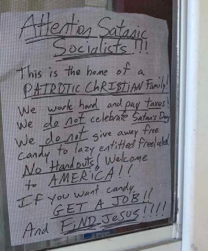 Handwritten Halloween fails sign on a door screen warning against giving out free candy to trick-or-treaters.