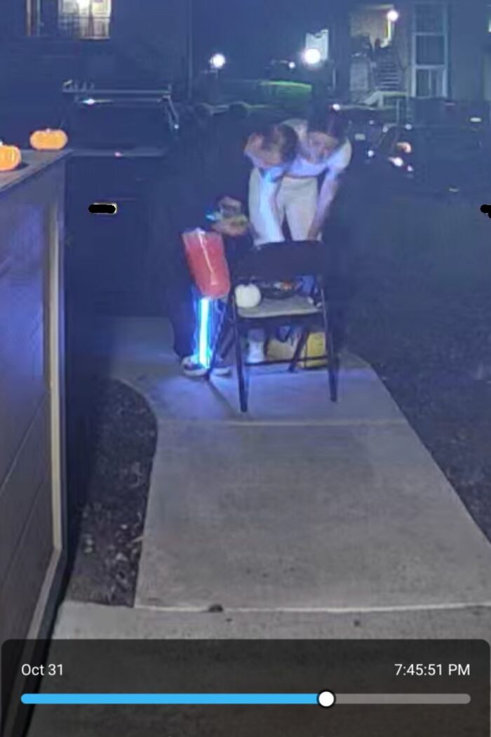 Two children dressed in black and white costumes accidentally leaving candy outside during Halloween fails at night.