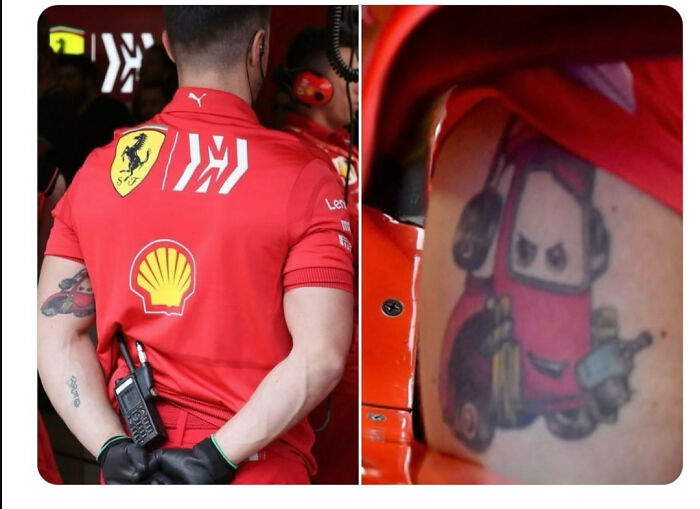 Person wearing a red Ferrari shirt with a tattoo of a cartoon forklift on their arm in a candid moment.