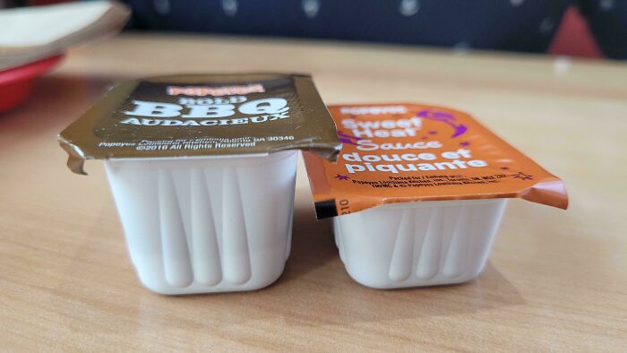 Two small condiment containers on a table showing examples of sneakflation with reduced product size and packaging.