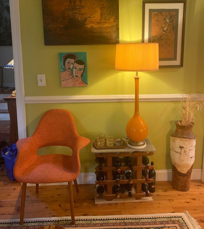 Mid-century orange chair and vintage table lamp in a cozy room, showcasing thrift store jackpot style and decor finds.