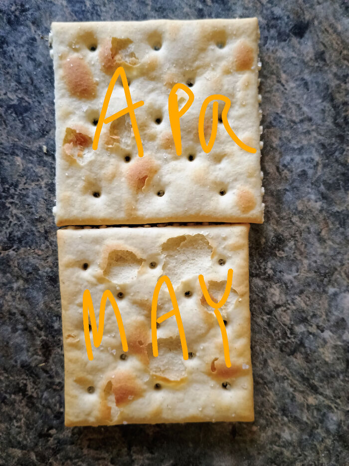 Two salty crackers on a dark surface illustrating sneakflation with one cracker noticeably smaller than the other.