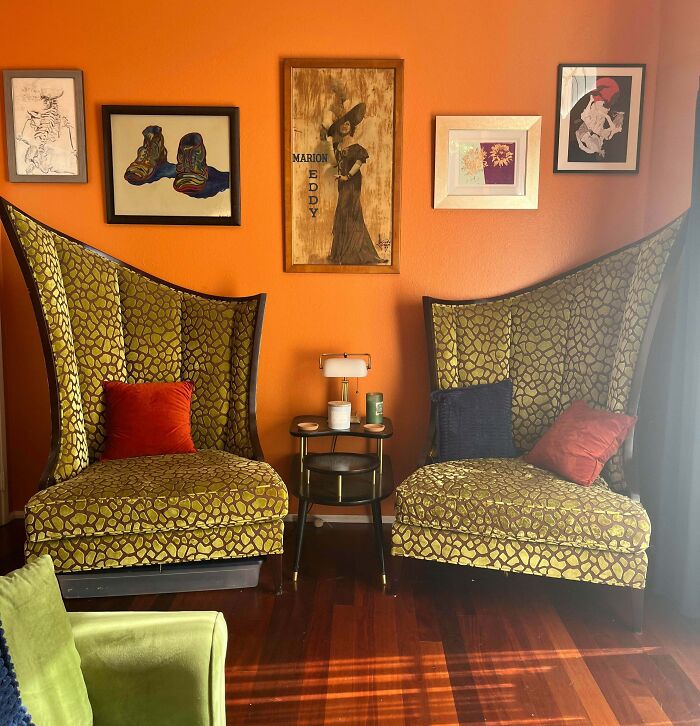 Two vintage high-back patterned chairs with colorful pillows in a cozy room showcasing thrift store jackpot finds.